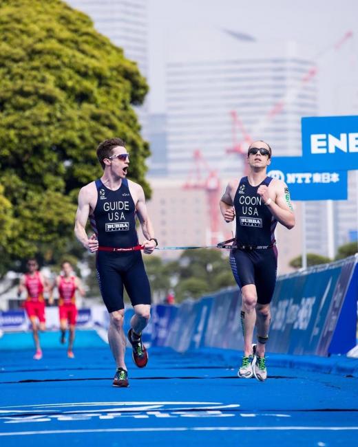 Kyle Coon running to the finish line along with his guide.