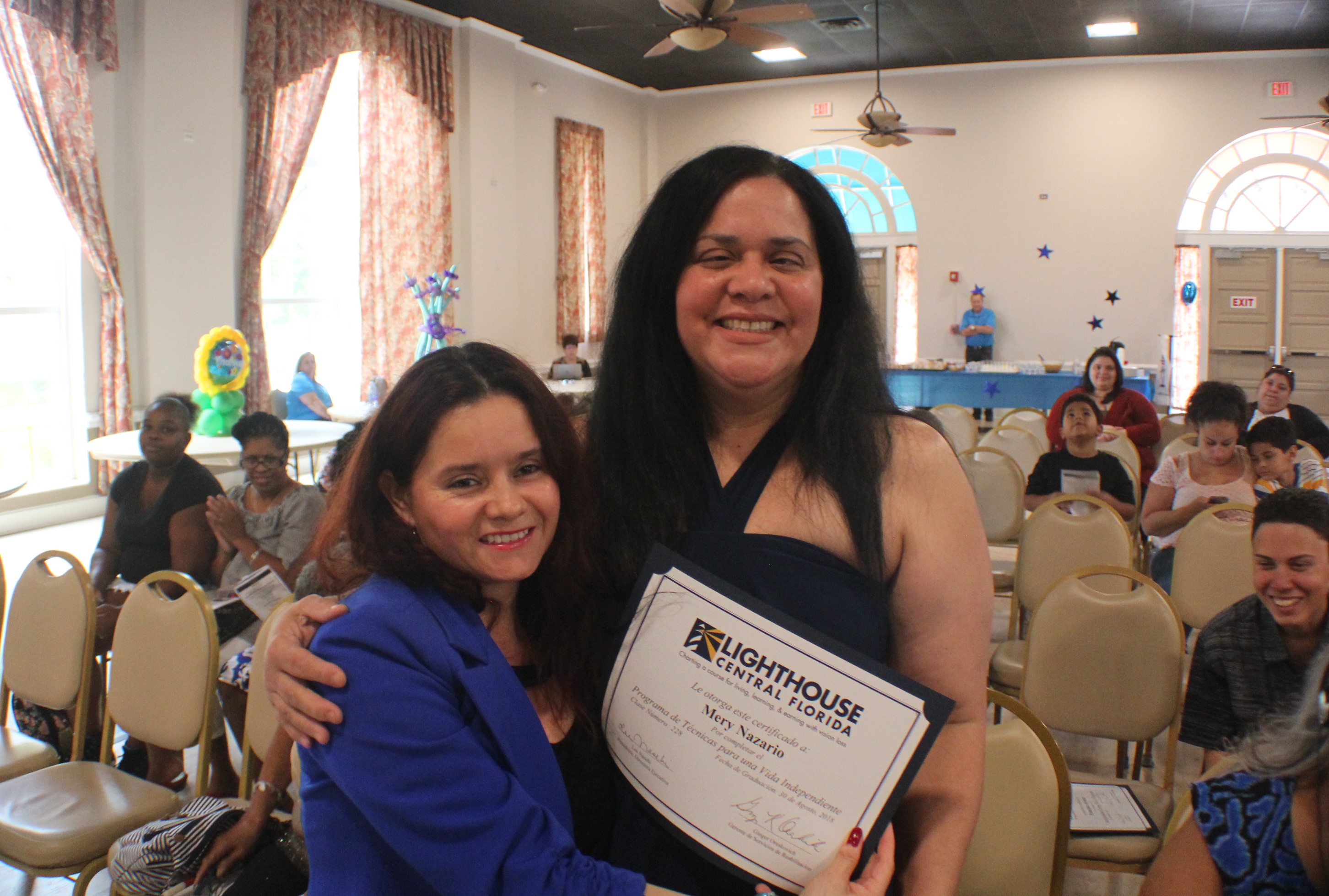 Lighthouse staffer, Maria [left] embraces graduate from recent Foundations of Daily Living course